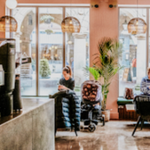 Cafe interior with customers, baby carriage and windows in background