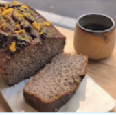 Sliced loaf cake with a cup of coffee on a white plate