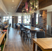 Interior view of a restaurant with tables, overhead decor, and seating