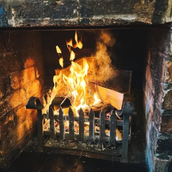 Fireplace with burning wood. Flames and heat in a cozy, warm setting.