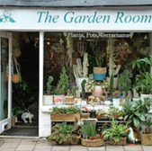 The Garden Room shop front displays plants, pots, and terrariums for sale.