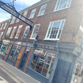 Fossgate sign above York building, displaying shop fronts on street, the Dog Friendly Map