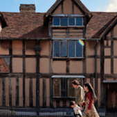 Family walks past Shakespeare's Birthplace, Stratford upon Avon, historic building exterior.