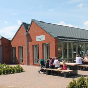 People at cafe with text The Pavilion Cafe in Lincoln, outdoor seating area.