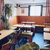 Cozy restaurant interior with tables, chairs, and a window; Cheltenham setting.