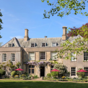 Large stone building with red umbrellas and blue sky background. Attractions.