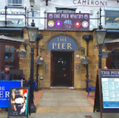 The Pier Whitby pub entrance, with visible text and signage. Whitby, dog friendly.