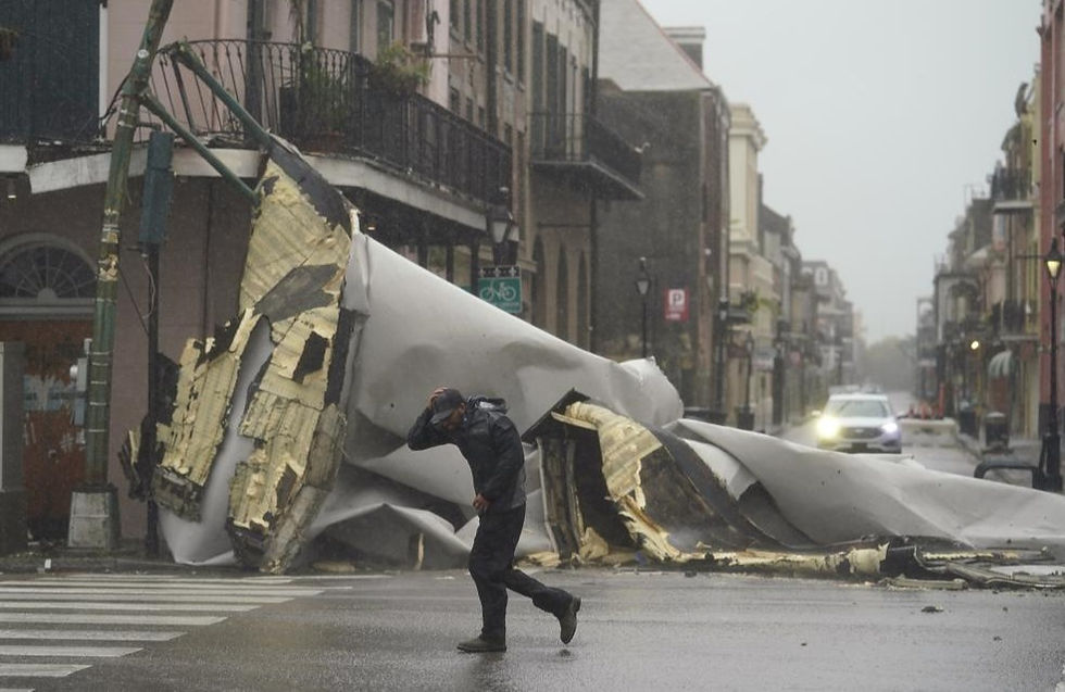 Un hombre pasa por una sección del techo que se desprendió de un edificio en el Barrio Francés por los vientos del huracán Ida, el domingo 29 de agosto de 2021, en Nueva Orleans.