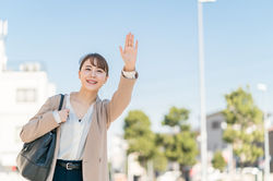 手を挙げてタクシーを呼んでいる女性