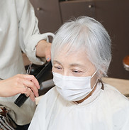 理容店で髪をセットするシニア女性