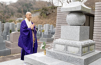 びわ湖霊園内平願寺の合祀墓前で祈る住職