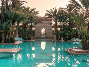 Beautiful hotel resort pool at sunset with tropical trees