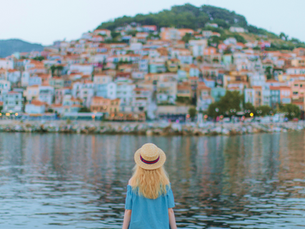Woman enjoying the view of a seaside city at dusk