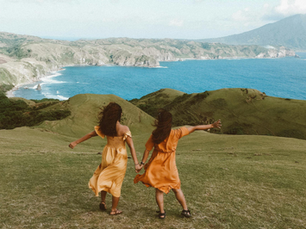 Women basking in the sunshine and incredible view of rolling hills against a blue shoreline