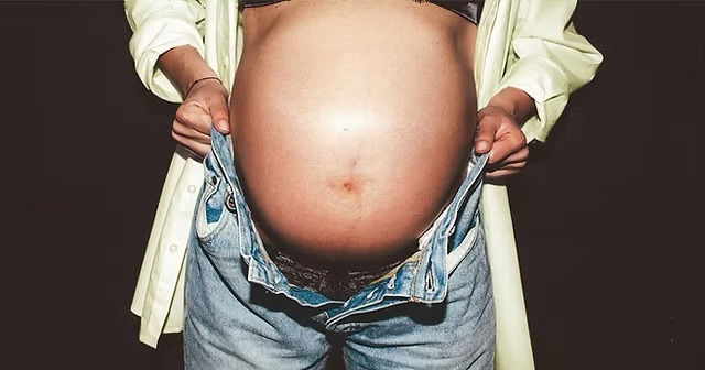Pregnant woman holding her belly while discussing laser treatments during pregnancy