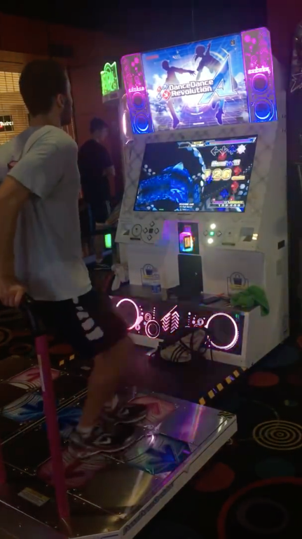 Chike playing DDR Ace in an arcade