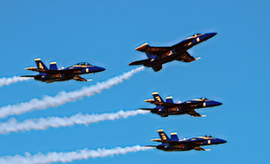 Five fighter jets fly in formation leavi