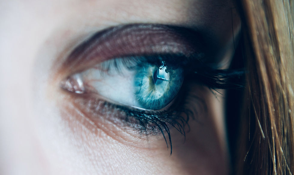 A woman's eye showing reflection of a window