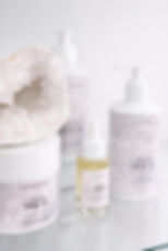 Linden House haircare collection with scalp exfoliant, hair oil, shampoo and conditioner in a minimal luxury setting with crystal