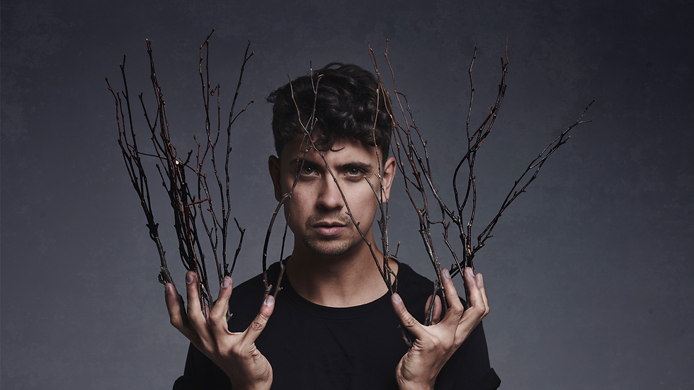 ben hart with sticks extending from his fingers like a witch to poromote ben hart: heX at edinburgh fringe 2024