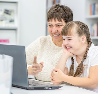 Teacher at laptop with child