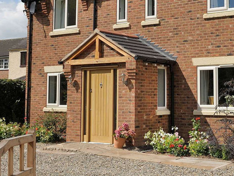 A modern brick home with a front porch and wooden door