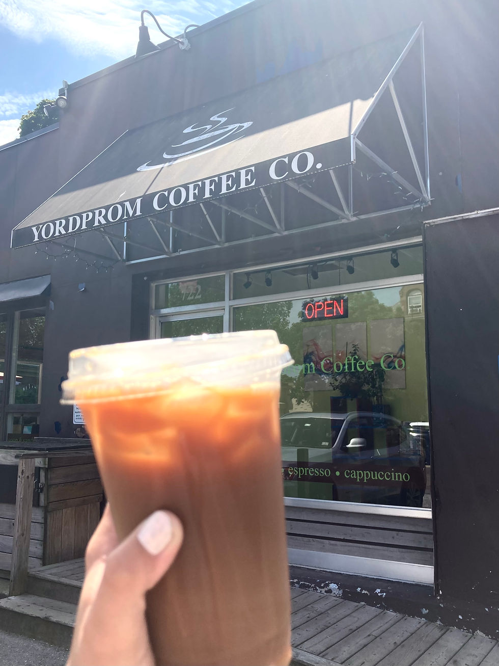 iced coffee in front of Yordprom Coffee sign