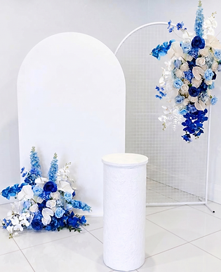 White arch set mesh with blue floral faux arrangement hire.png