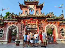 Tourists taking photos in front of an ancient temple gate in Hoi An during 10-day Vietnam tour