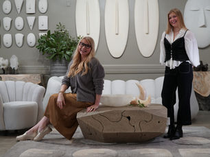 Two young, blonde women in a neutral living space with lots of natural design elements.