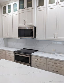 Custom shaker style cabinetry with uppers to ceiling with glass fronts & smart lighting system, lowers with pots & pans pull outs, toe kick drawers, trash