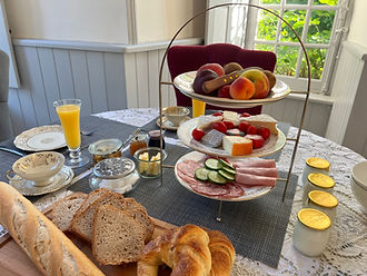 „Frühstück im Château de Planquery in der Normandie mit regionalem Käse, Baguette, Croissant und frischem Obst nahe Omaha Bea