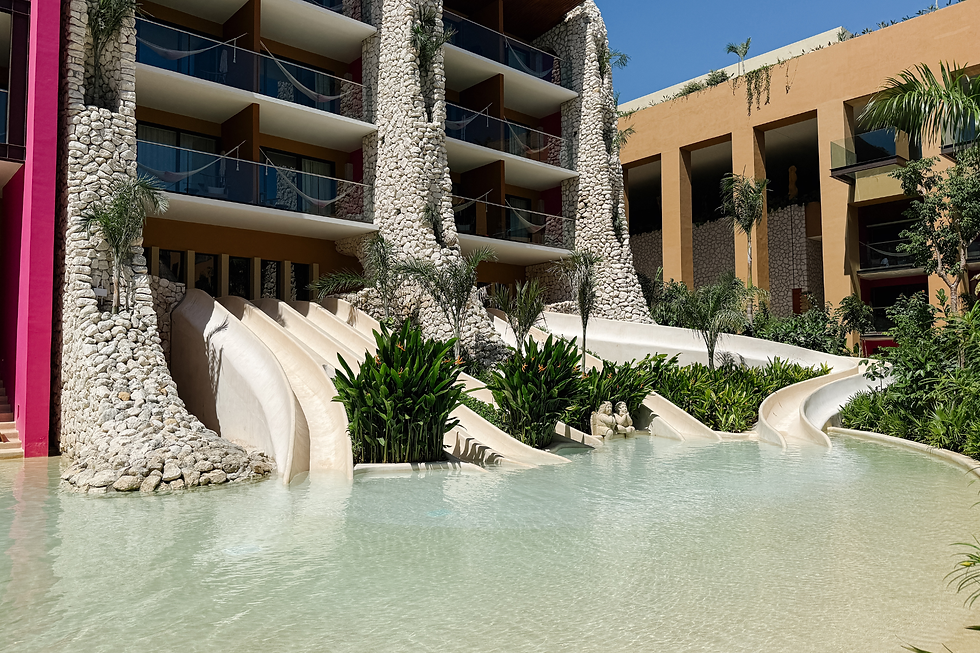 Waterslides at Hotel Xcaret Mexico with shallow splash pool for families.