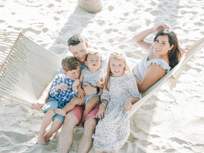 A family on a hammock of 5 enjoying their beach vacation