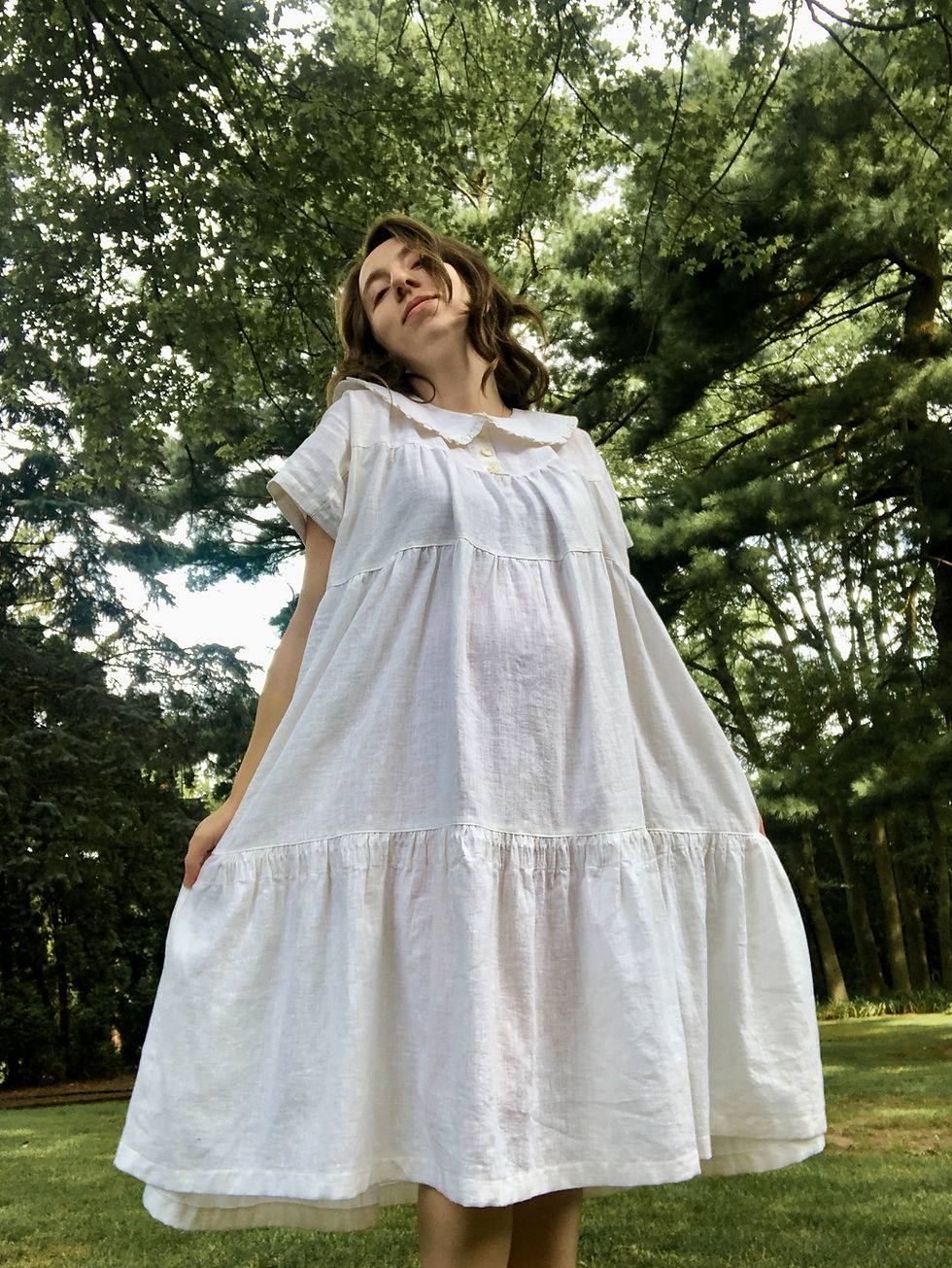 A woman wearing a handmade white tiered maxi dress