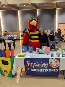 Founder with mascot at a stand