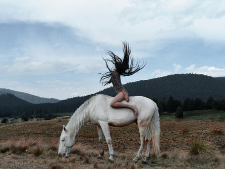 Woman on a white horse flipping her hair