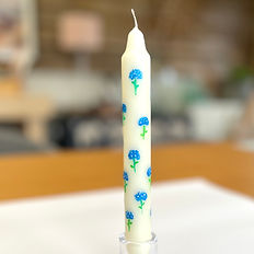 A dinner candle hand painted with blue hydrangeas