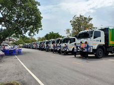 กลุ่มรถบรรทุกจอดเรียงราย บริษัท คลีน มหานคร จำกัด พร้อมป้าย นคร ระยอง