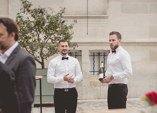 Service maître d'hotel - Serveurs en tenue avec une bouteille de champagne lors d'un événement élégant en extérieur, organisé par le Chef Thibaut Servas pour une réception privée ou professionnelle.