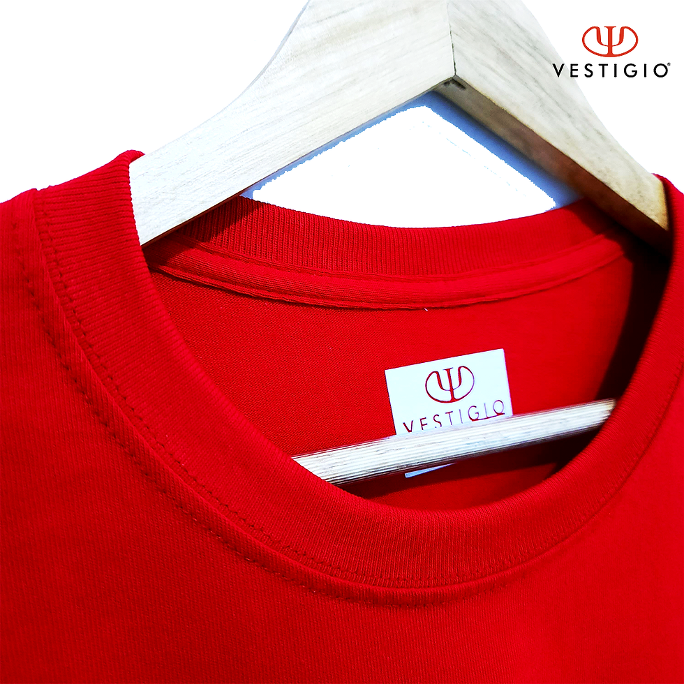 Miniatura: Camiseta roja con etiqueta VESTIGIO y logo en colgador de madera.