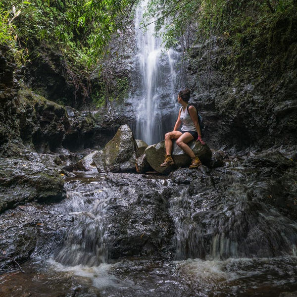 hiking taking a rest at a waterfall in hawaii