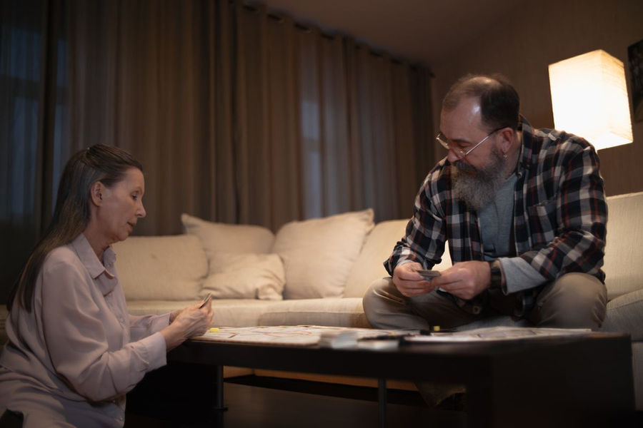 Older couple enjoying a board game in their living room