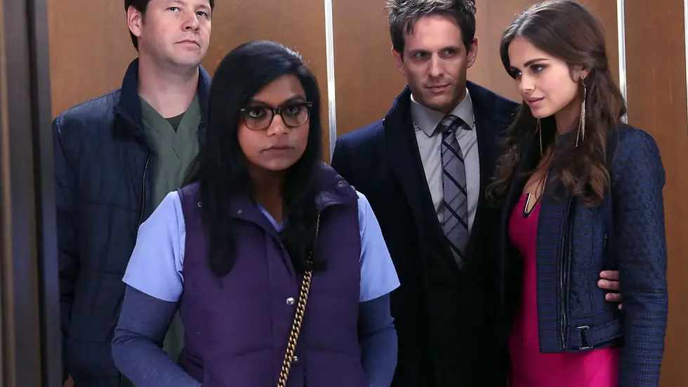 Mindy Lahiri and three coworkers stand together in an elevator.