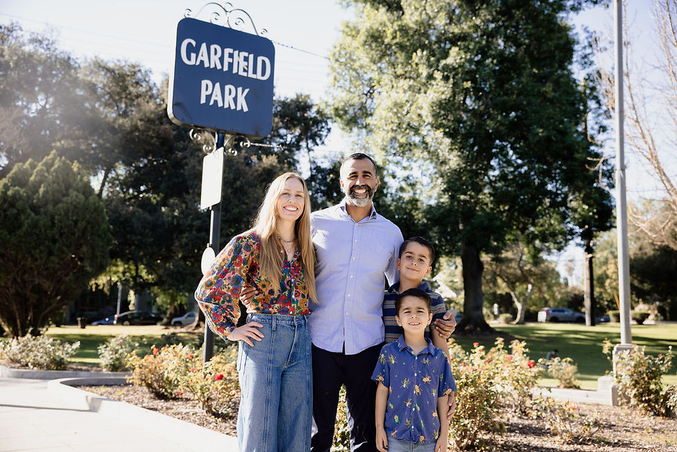 Family standing together under a Garfield Park sign