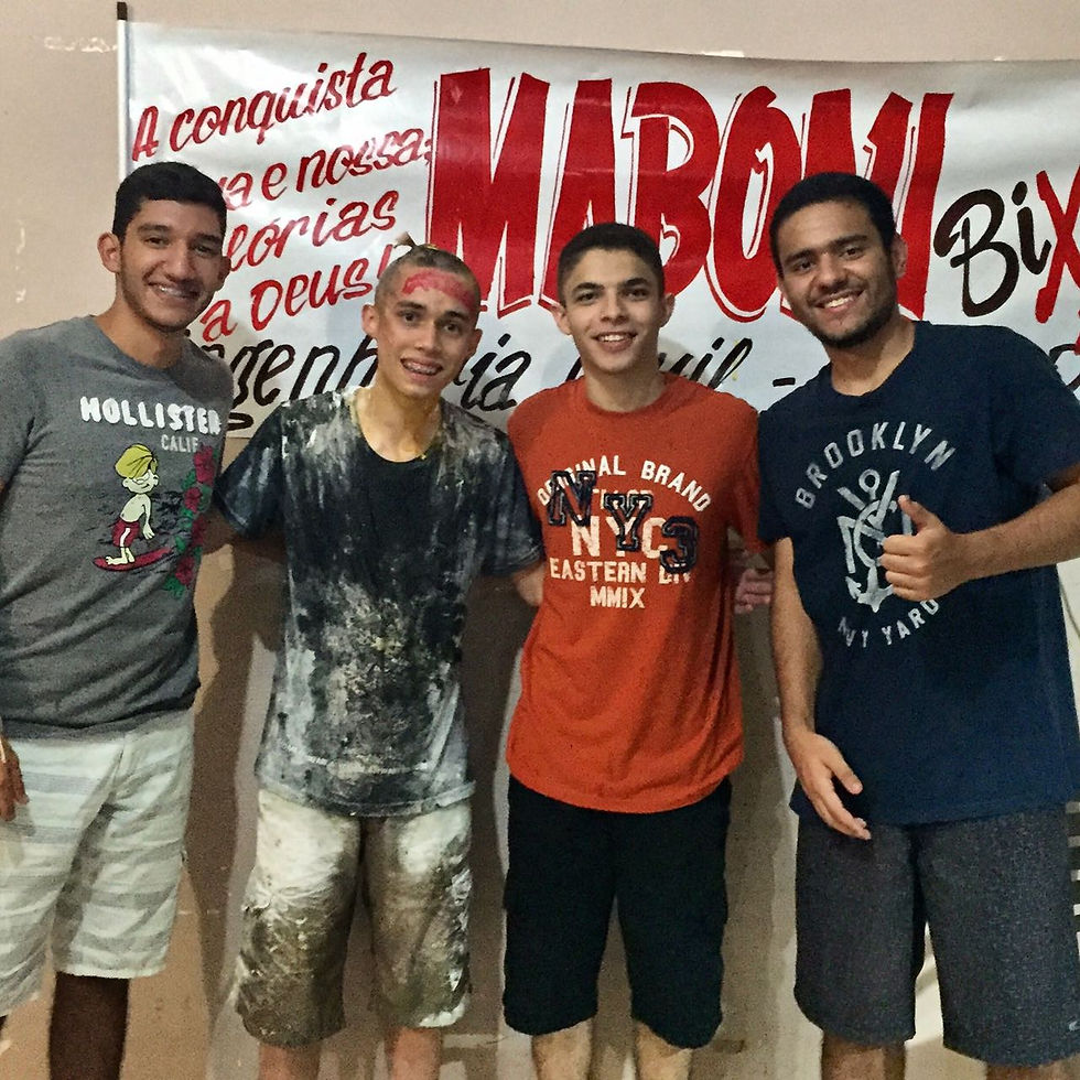 João Paulo Maboni junto a seus amigos, com a faixa do trote atrás deles