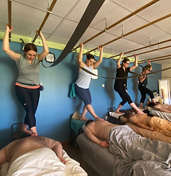 Barefoot Massage Therapist Trainees performing myofascial barefoot massage techniques in a classroom.