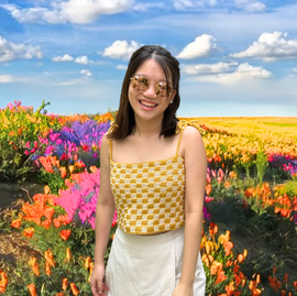 A checkered top with adjustable tie-straps and a lace-up back. The top is made of yellow and cream squares. 