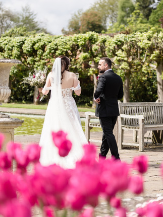 Tulips in the foreground and bride and groom walking away chatting relaxed