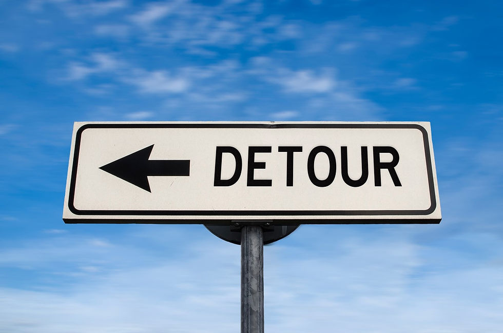 A detour sign against a cloudy blue sky